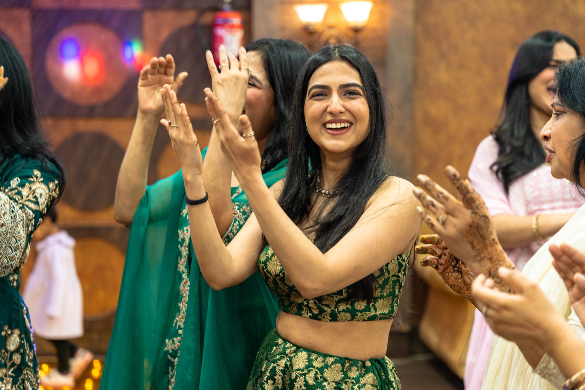 Guests clapping and dancing at a sangeet